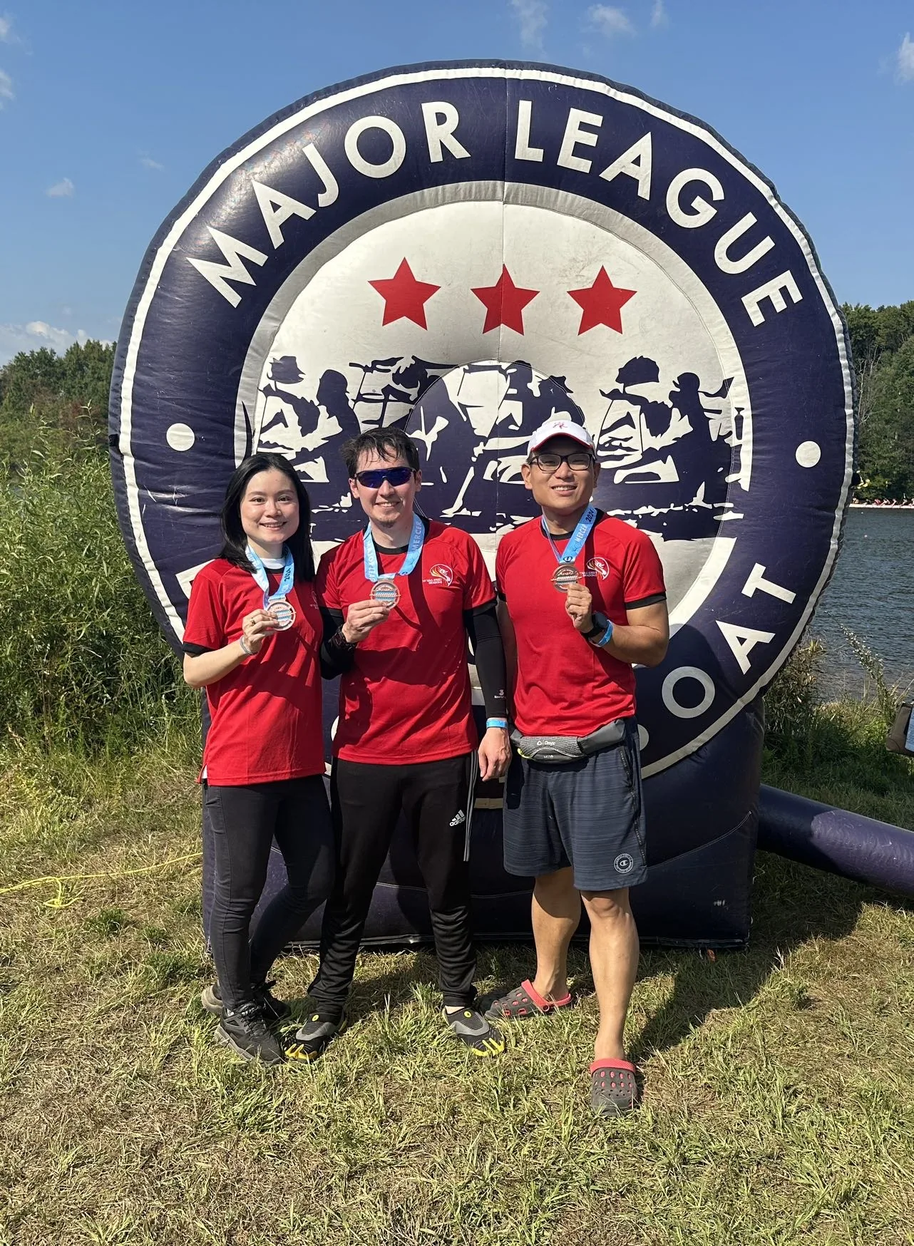 Shuo Zhang with Lin and Emile at a dragon boat event in 2024 holding medals